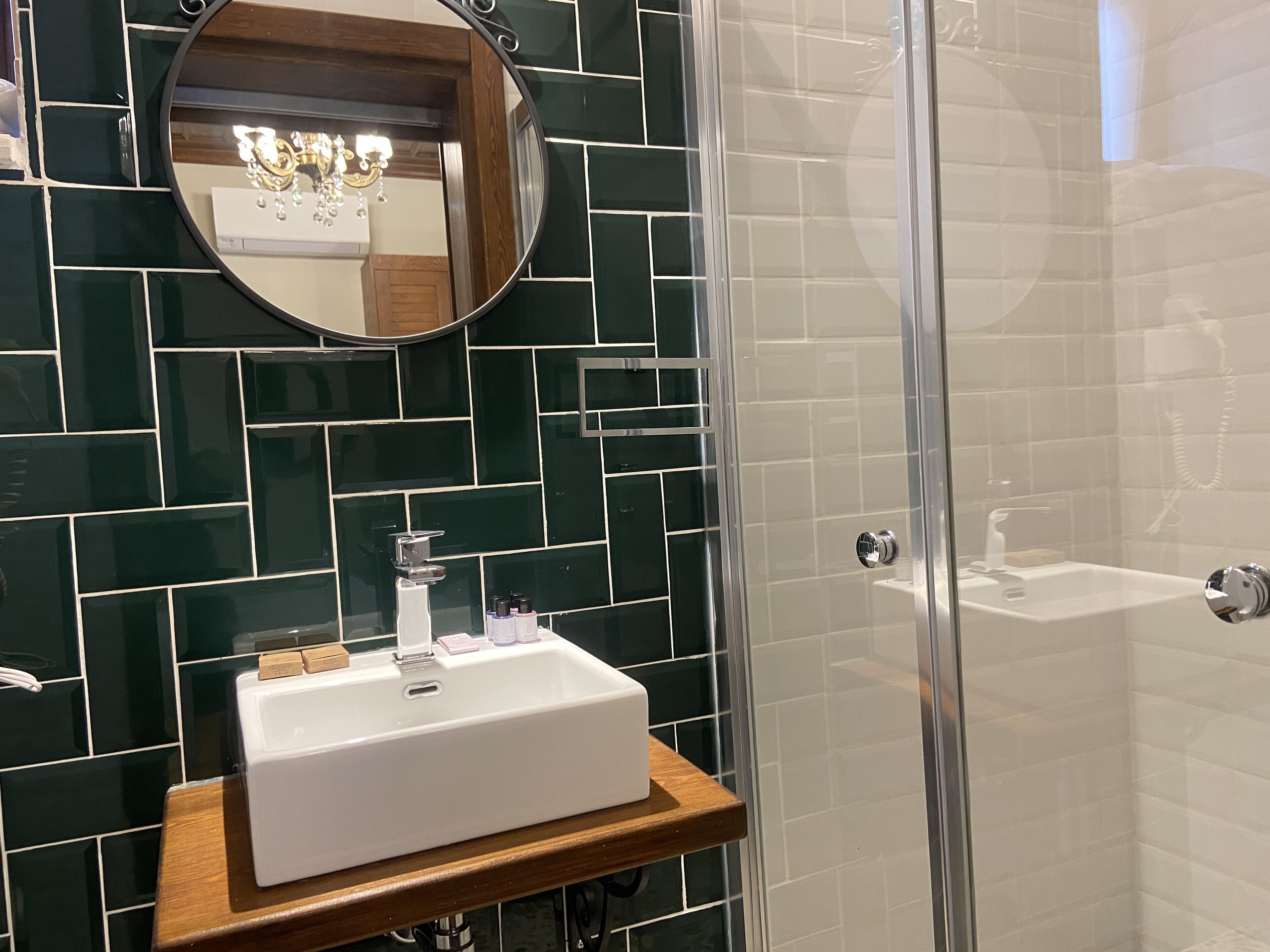 A bathroom with a white sink, a mirror, and a shower area.