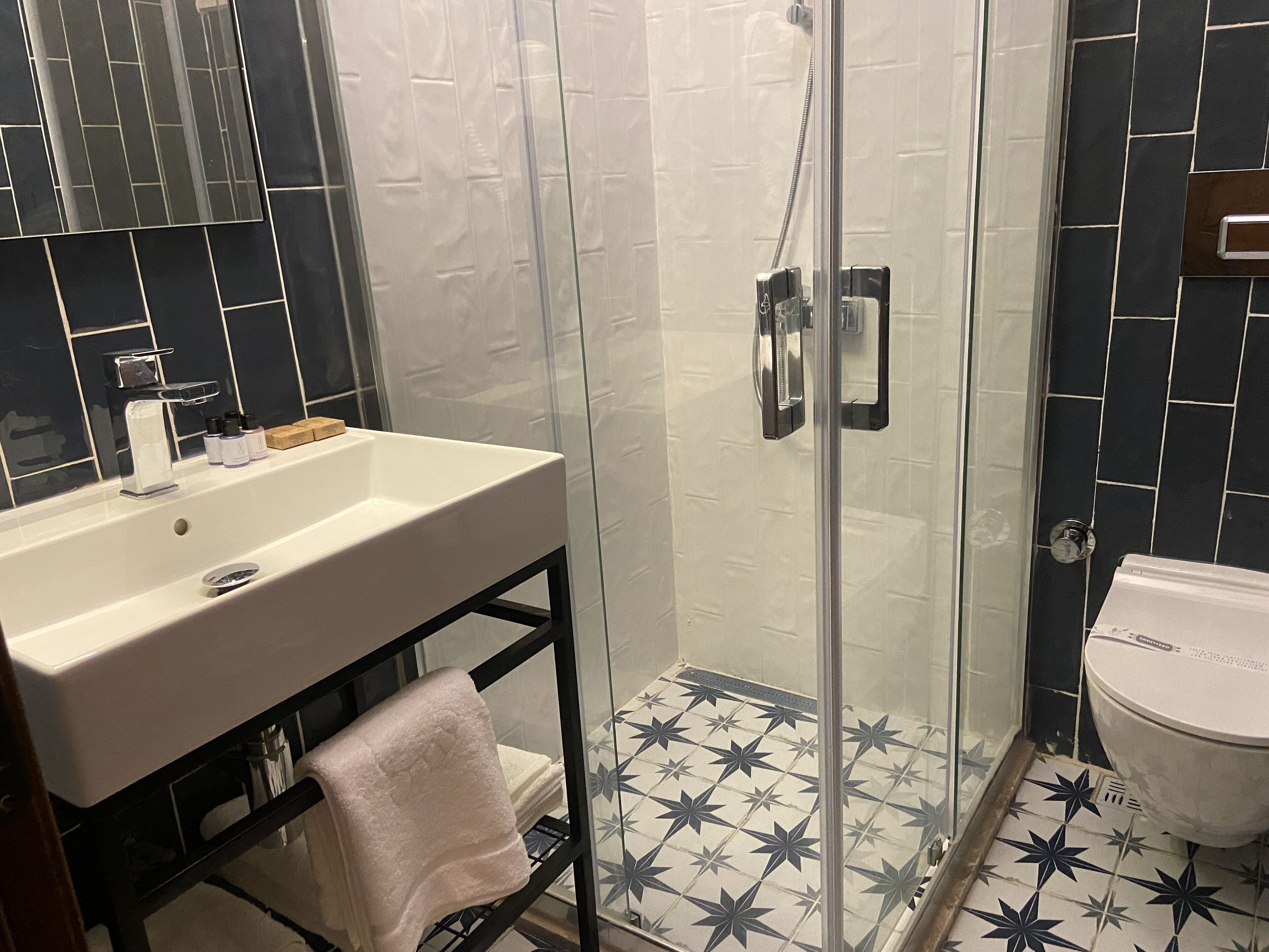 Une salle de bain avec une douche à parois de verre, un lavabo blanc et des toilettes.