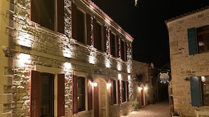 A stone building with red shutters and a sign that reads "Stella Home Office." - Dionysos 1789 Boutique Hotel (Foça)