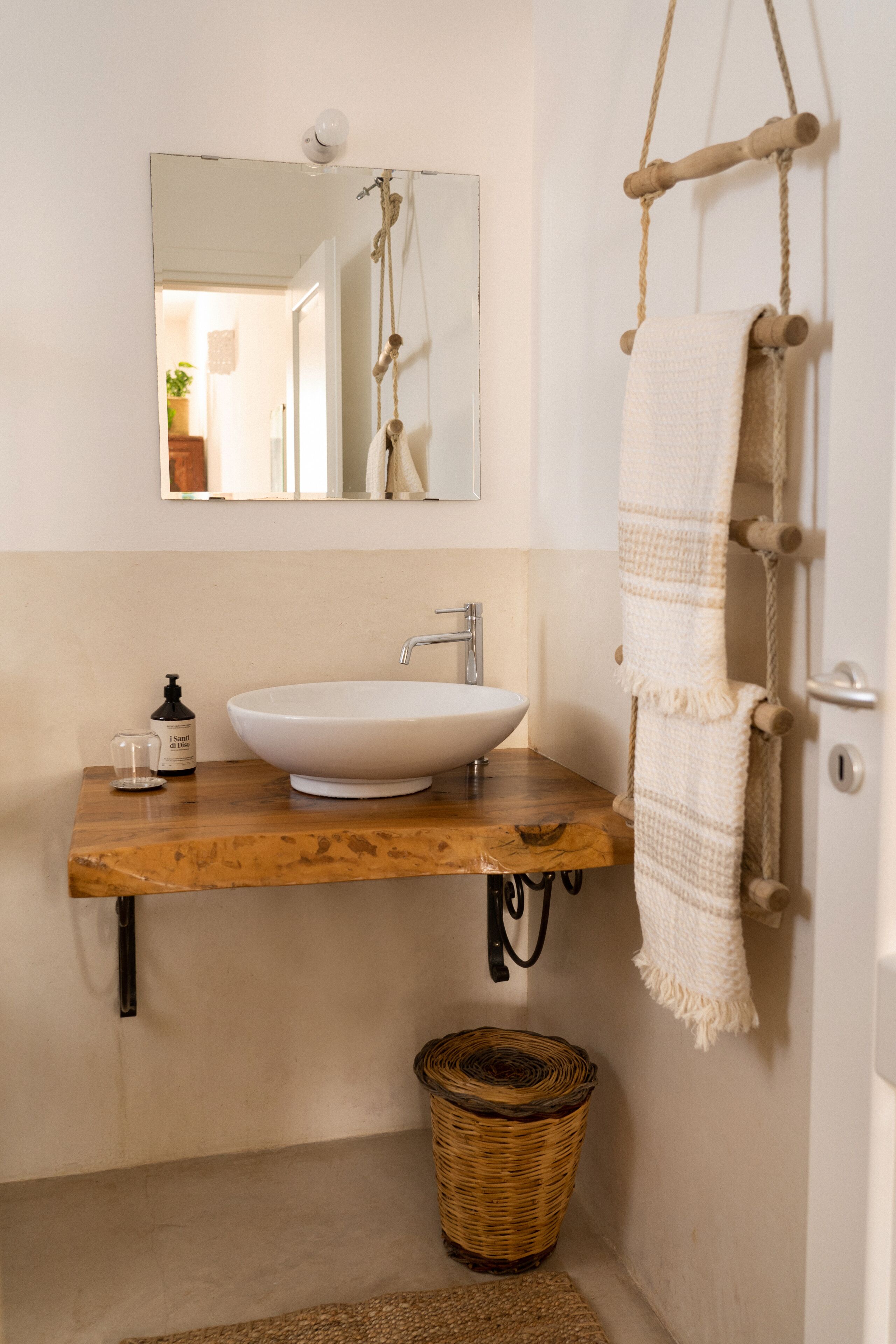 Une salle de bain avec un meuble-lavabo en bois, un lavabo blanc et un porte-serviettes suspendu.