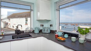 A kitchen with a view of the sea, a toaster, a kettle, and a sink. - 2 bedroom accommodation in Brixham (Brixham)