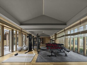 Ett modernt gym med träningsutrustning, stora fönster och ett trägolv.