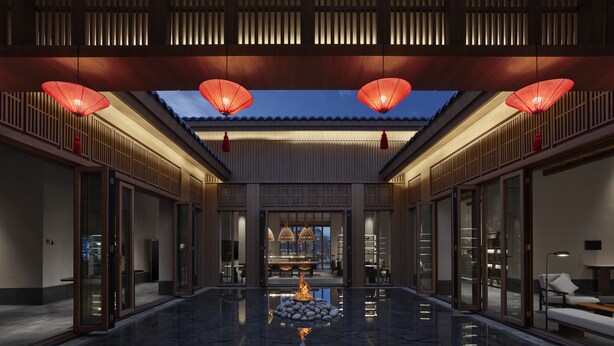 A traditional-style lobby with a stone floor, wooden paneling, and red lanterns. - Angsana Chengdu Wenjiang (Chengdu)