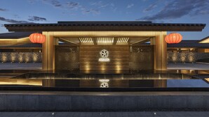 A modern building with a traditional architectural style, featuring a stone wall and a reflective water feature in front. - Angsana Chengdu Wenjiang (Chengdu)