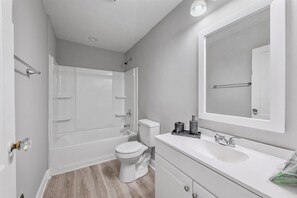 A compact bathroom with a toilet, sink, and bathtub. - Newly remodeled 4BRs next to OSU&Expo, 2 FREE Parking. (Columbus)