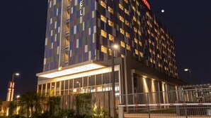 A modern hotel with a checkered facade, illuminated signage, and a gated entrance. - Ibis Kolkata Rajarhat (Barasat)