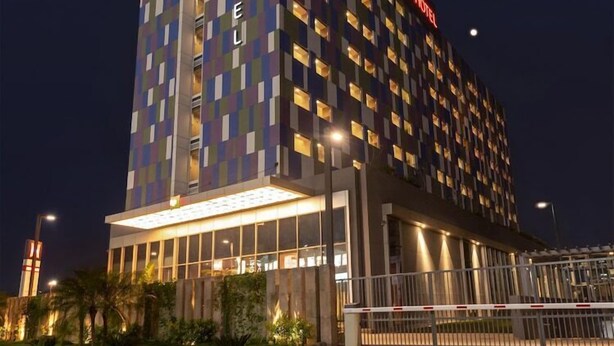 A modern hotel with a checkered facade, illuminated signage, and a gated entrance. - Ibis Kolkata Rajarhat (Barasat)