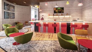 A modern bar area with red and green bar stools, a wooden ceiling, and a TV screen. - Ibis Kolkata Rajarhat (Barasat)