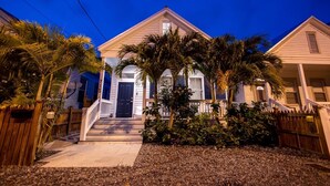 A two-story house with a front porch, a staircase, and a wooden fence. - THE CLASSY CONCH- Old Town Key West (Key West)