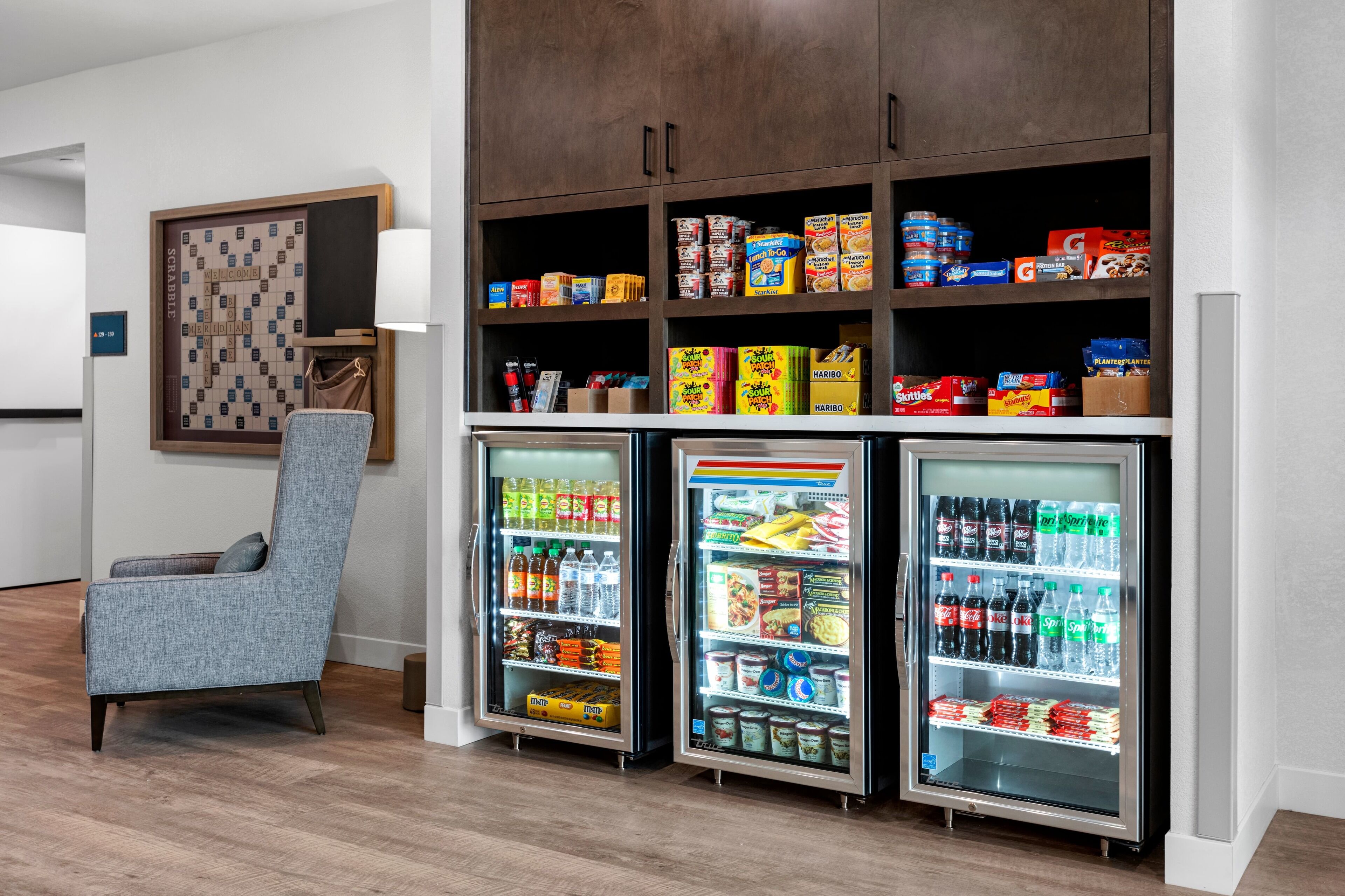 A hotel room with a seating area, a minibar, and a snack bar.
