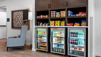 Una habitación de hotel con zona de estar, minibar y bar de aperitivos.