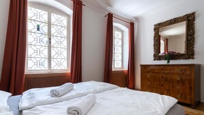 Une chambre d’hôtel avec un grand lit, une commode en bois et un miroir.