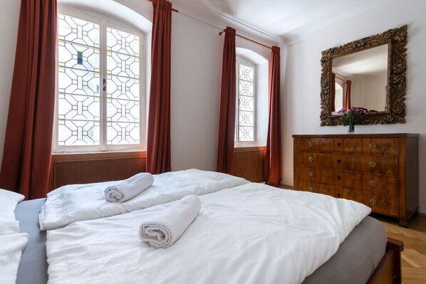 A hotel room with a large bed, wooden dresser, and a mirror.