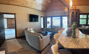 A cozy living room with a fireplace, a dining area with a granite countertop, and a kitchen with wooden cabinets.