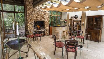 Un intérieur rustique avec une cheminée en pierre, des meubles en bois et une table à manger en verre.