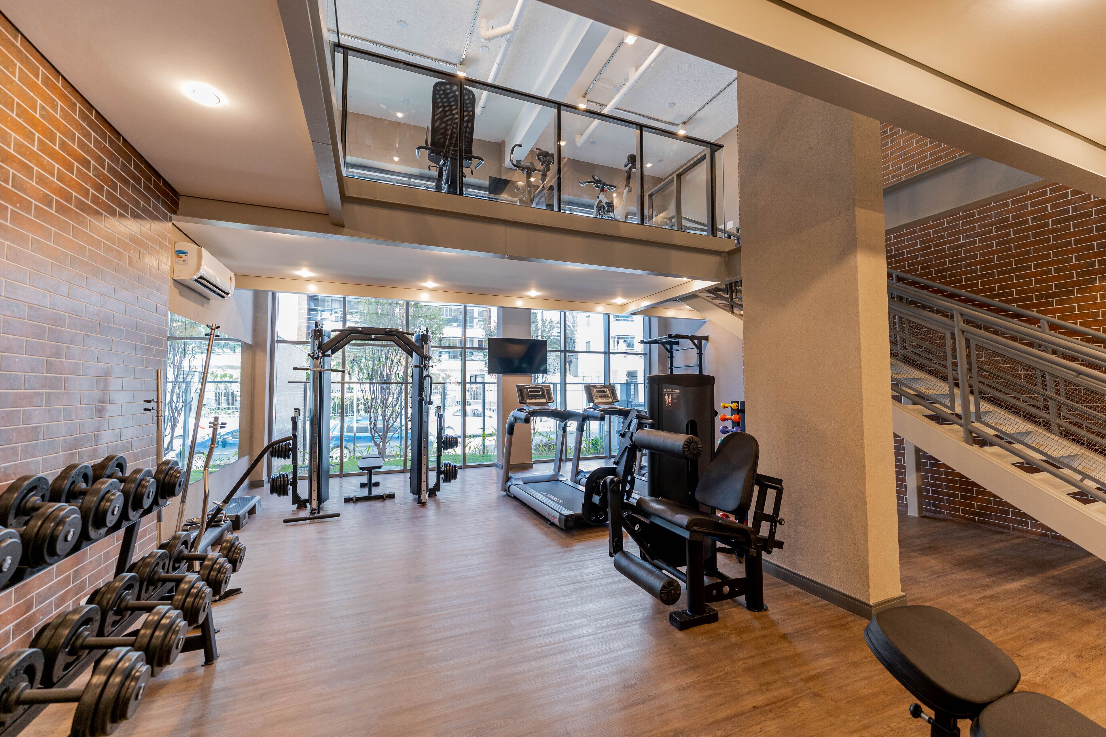 A gym with weight racks, treadmills, and exercise equipment.