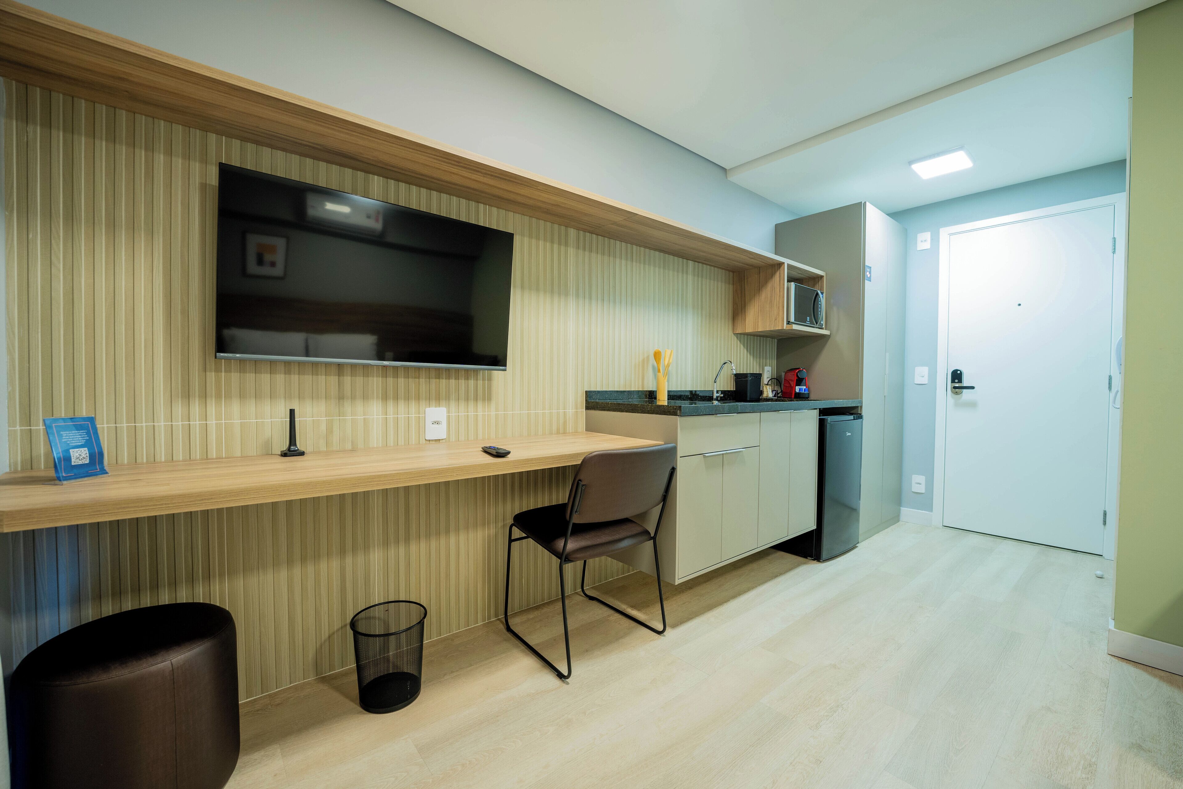 A modern kitchen with a wooden countertop, a built-in microwave, and a sink.