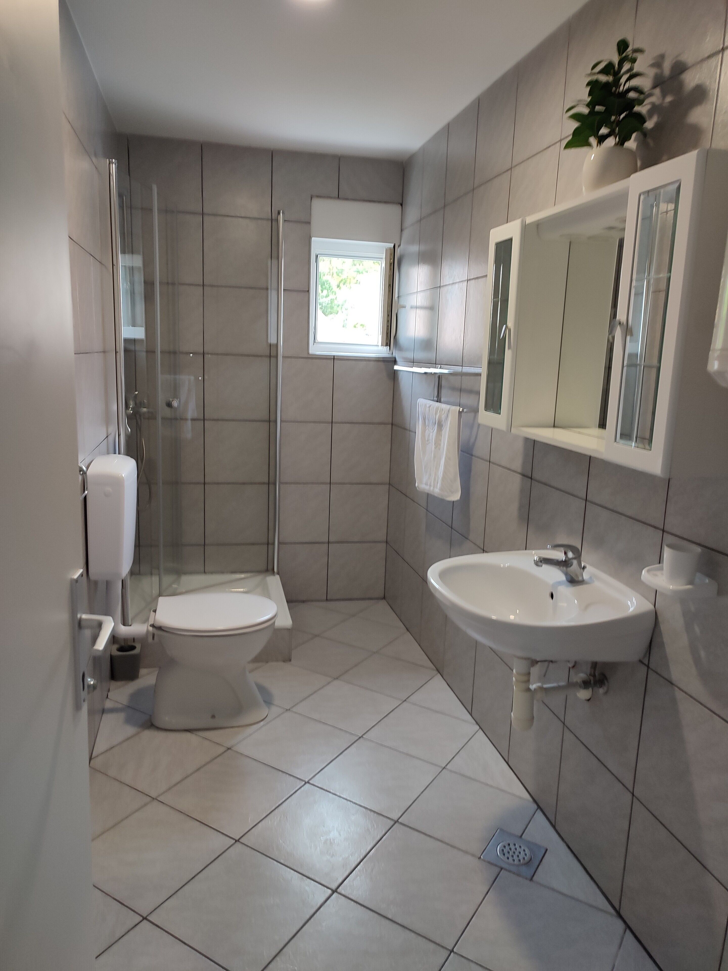 Une salle de bain moderne équipée de toilettes, d’un lavabo et d’une douche.