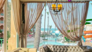 A luxurious room with a view of a pool and palm trees. - Hotel Marabout - Families and Couples Only (Sousse)
