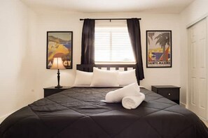 Relax in a cozy retreat with a neatly made bed, bedside table, and warm lighting.