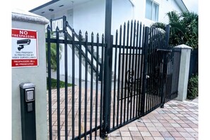 Secure gated entrance with video surveillance and a locked gate.