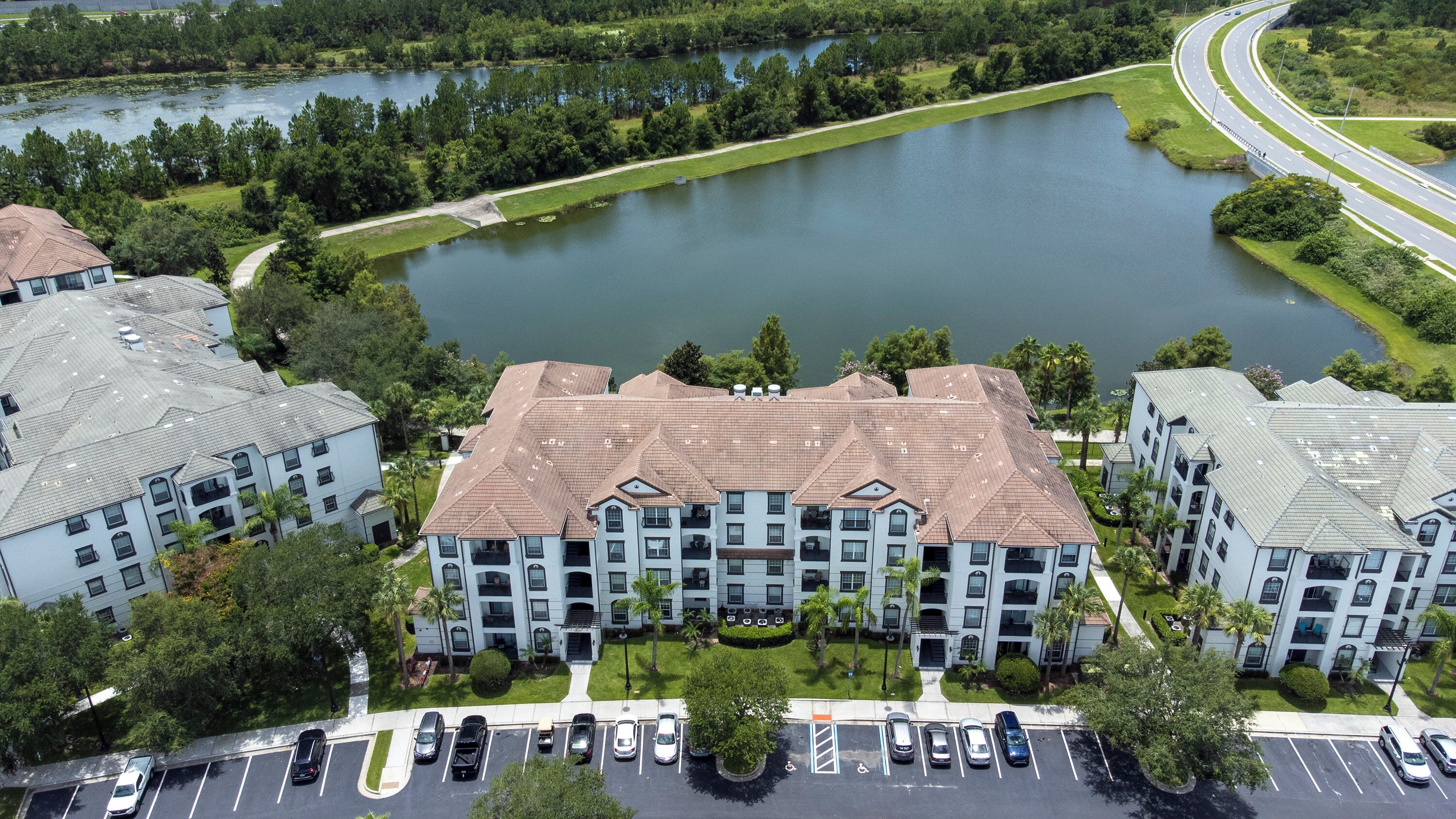A multi-story residential building with a central courtyard and a parking lot.