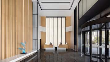 A modern reception area with a wooden panel wall, a marble floor, and a glass door leading outside.