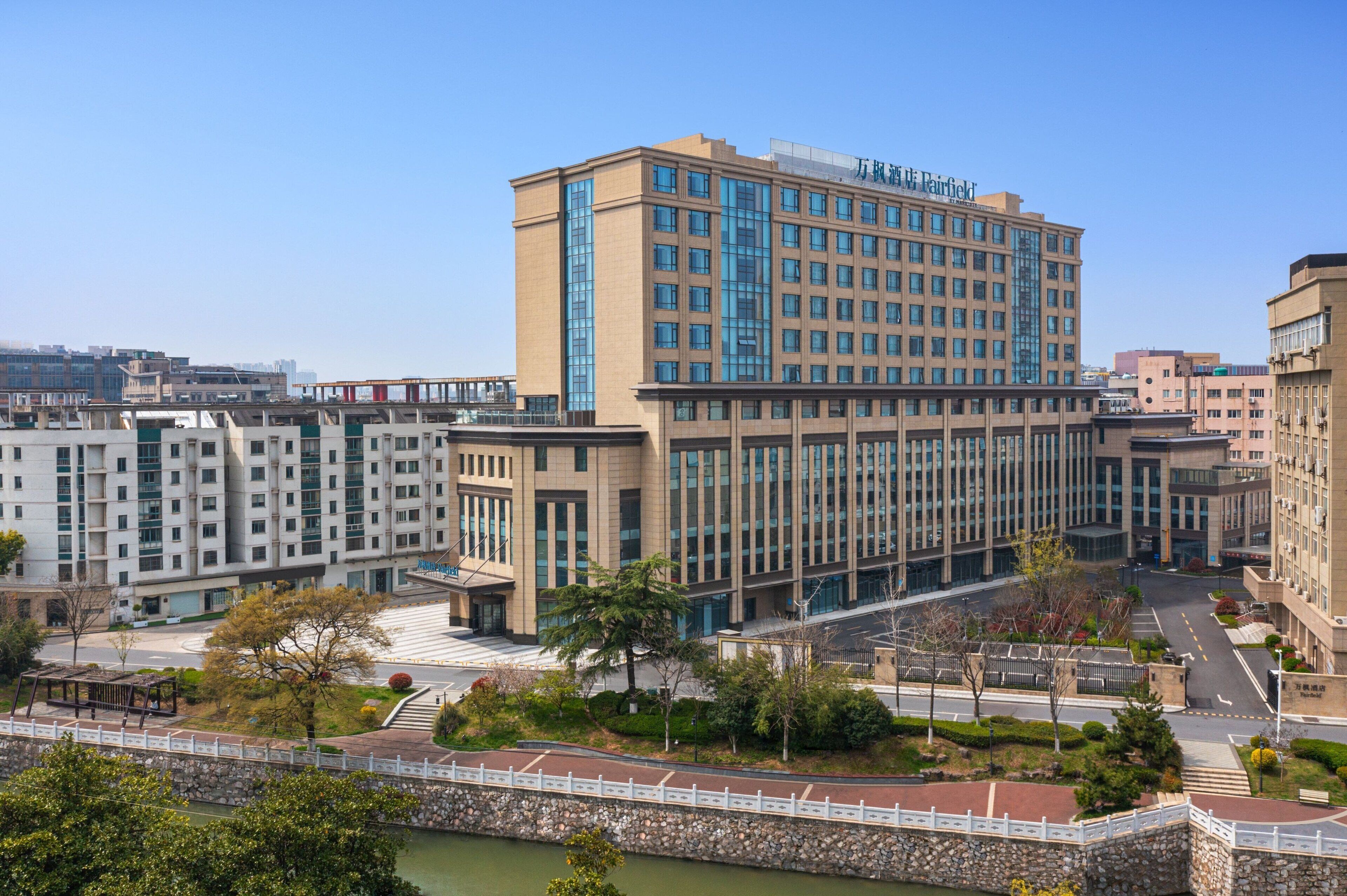 A multi-story hotel with a modern design, featuring a prominent entrance and a landscaped courtyard.