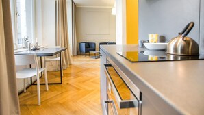 Een moderne keuken met een eethoek, houten vloeren en uitzicht op de stad.
