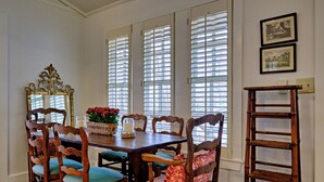 Un comedor con una mesa de madera, sillas y una escalera.