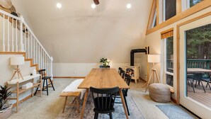 Une salle à manger spacieuse avec une table en bois, des chaises et une cheminée.