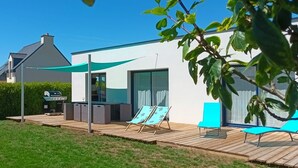 A modern house with a patio, outdoor seating, and a barbecue grill. - Le 26 - Erdeven - Gîte (ERDEVEN)