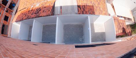 Un edificio con tejado de baldosas y planta baja de ladrillo.