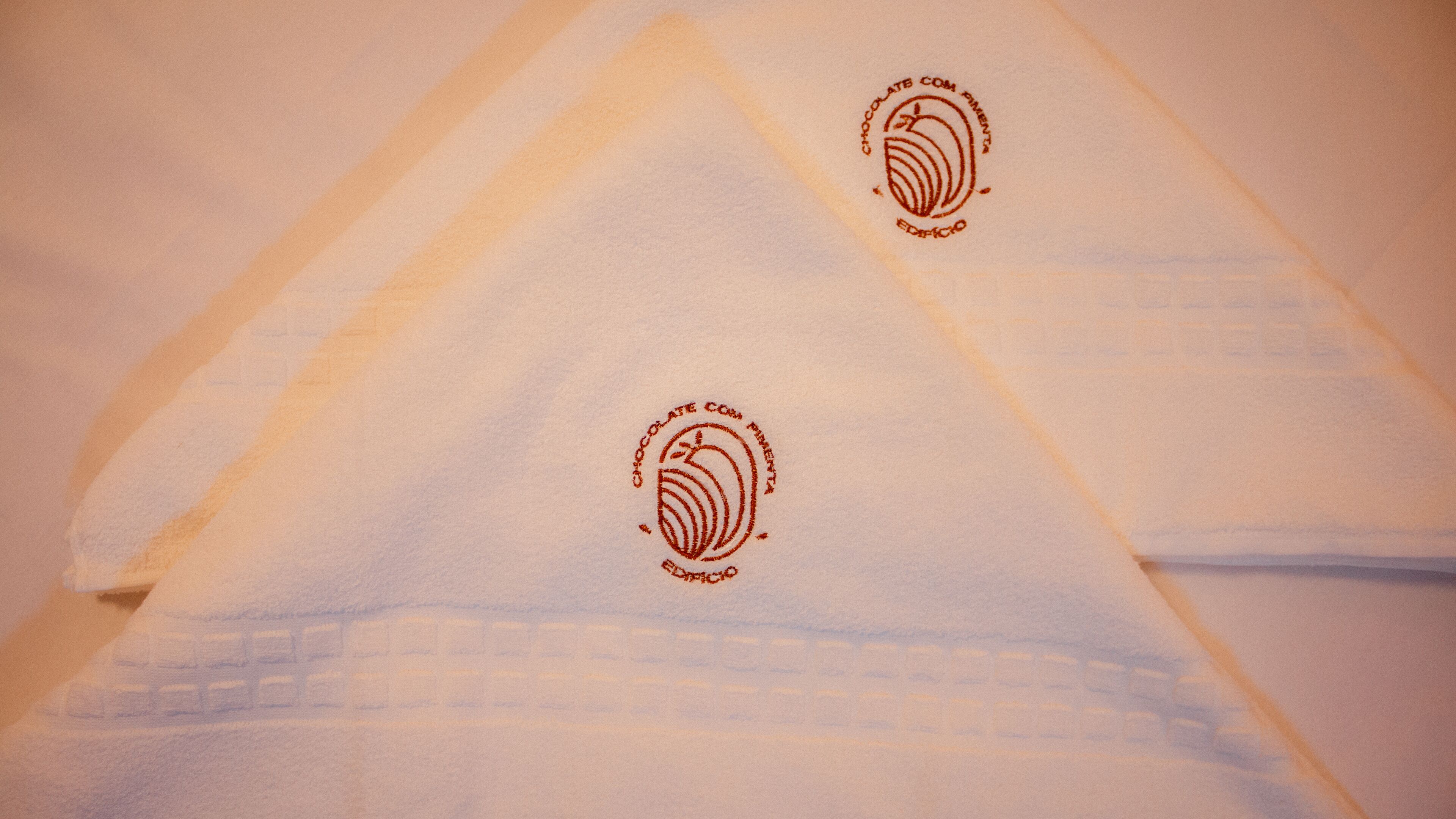 A white fabric with embossed text and a logo.