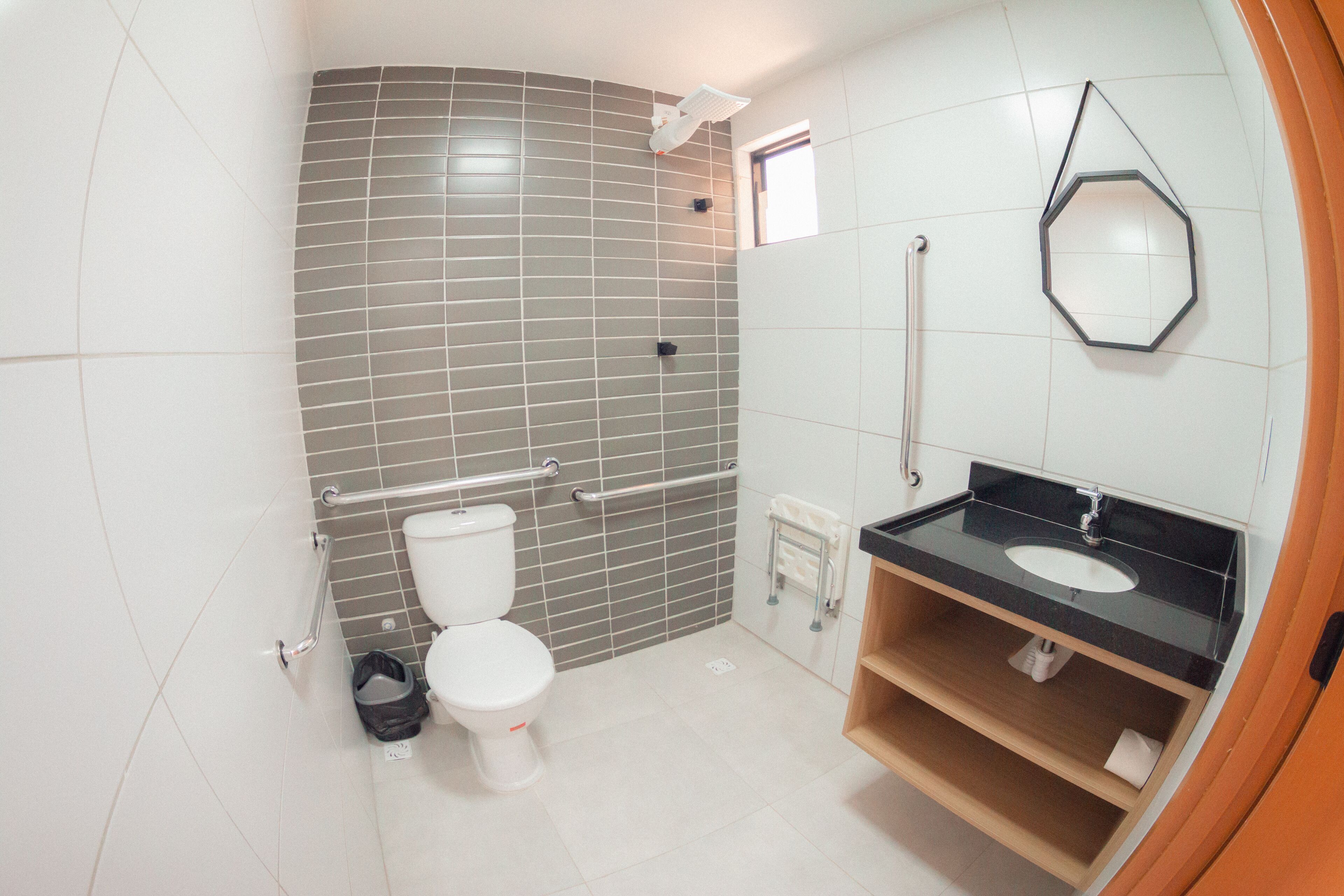 A bathroom with a toilet, a sink, and a mirror.