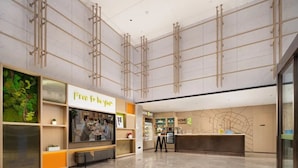A spacious lobby with a reception desk, a 'Free to Live' sign, and a 'Home & Me' store. - Home2 Suites by Hilton Chengdu Kuanzhai Alley (Chengdu)