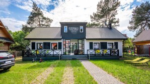 Ett tvåvåningshus med en veranda på framsidan, en uppfart och en inhägnad trädgård.
