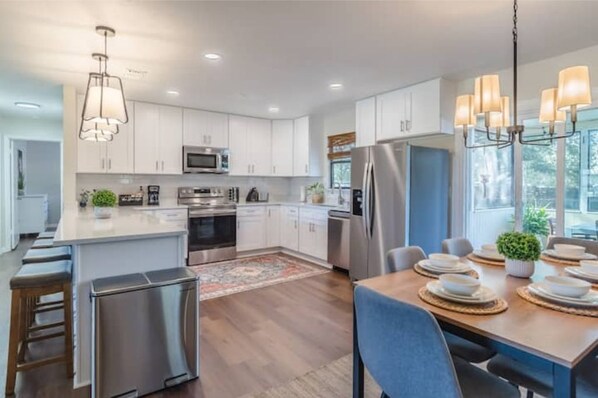 Enjoy meals in the kitchen with a central island, stainless steel appliances, and a dining area.