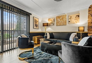 Relax in this stylish living room with a large sectional sofa, matching armchairs, and a patterned rug.