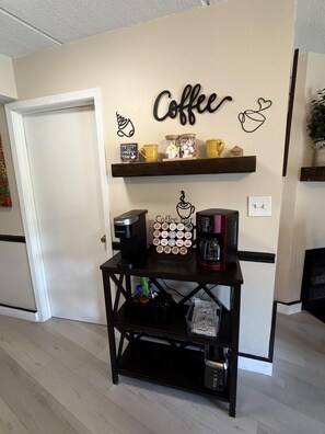 A coffee-themed wall decor with a coffee shop sign, a coffee machine, a coffee grinder, and a coffee bean display.