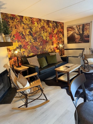 Un salon avec un canapé, un fauteuil à bascule en bois et une table basse.