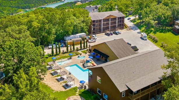 Un hotel con piscina, zona de estar al aire libre y vistas a un lago.