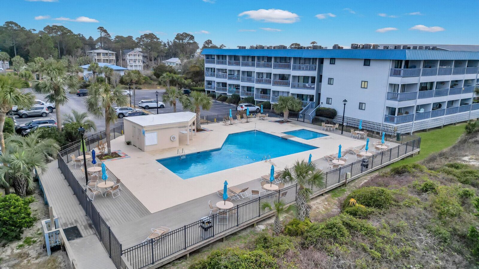 Un hôtel doté d’une piscine, d’un espace extérieur aménagé et d’un bâtiment à plusieurs étages avec des balcons.