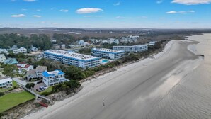 Un hôtel situé sur la côte, composé de plusieurs bâtiments, avec une plage et une vue sur l’océan.