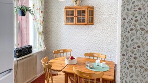 A dining area with a wooden table and chairs, a cabinet, and a radiator.
