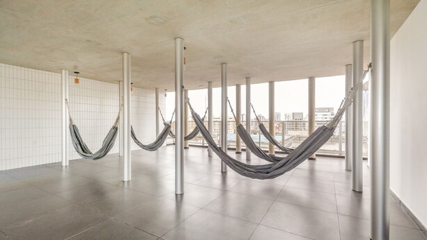 A spacious room with a tiled floor and large windows offering a city view. - OBA 142 - Super Estúdio Frei Caneca (São Paulo)
