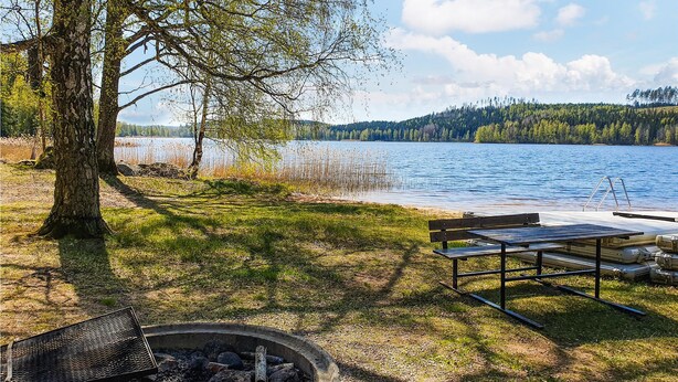 A lakeside campsite with a fire pit, picnic table, and benches. - Stunning home in Södra Vi with kitchen (Södra Vi)