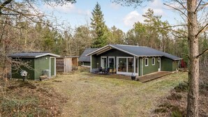 A small cabin with a porch and a covered outdoor seating area, surrounded by trees. - Beautiful home in Herning with WiFi (Herning)