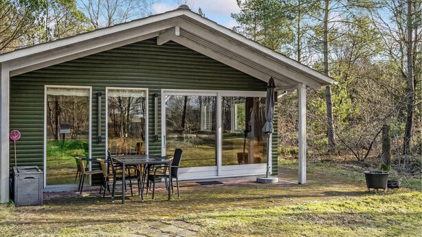A small, green wooden cabin with a porch, a table, and chairs. - Beautiful home in Herning with WiFi (Herning)