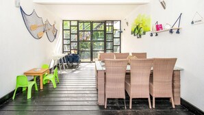 A room with a dining area featuring wicker chairs and a table, a small seating area with plastic chairs, and a large window with a view of greenery. - 1 bedroom beautiful apartment in Jaroslawiec (Jaroslawiec)